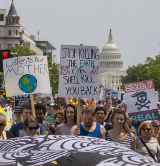 Protestors at the US capitol with signs calling on legislators to protect the planet