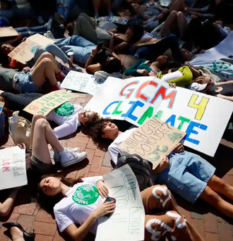 Young climate activists stage a ‘die-in’ across from the White House on Earth Day in April this year. Young teens lay down on the ground holding signs that read GCM 4 Climate and Climate Action Now