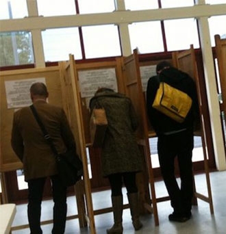 People voting in voting booths.