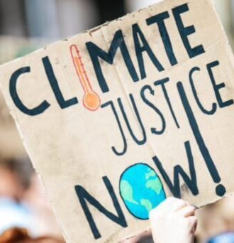 Protester holds up sign that reads Climate Justice Now