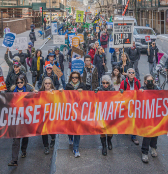 Seniors in New York City and a coalition of environmental groups marching with a banner that reads "Chase Funds Climate Crimes" at a rally on March 21, 2023 as part of a National Day of Action to pressure the major banks to stop financing the expansion of the fossil fuel industry