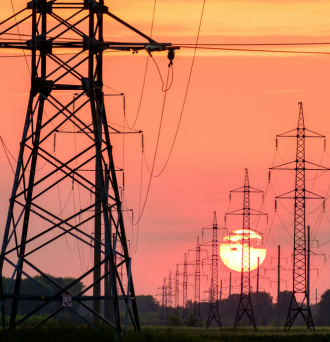 A photo of power lines in front of a bright red sunrise/sunset.