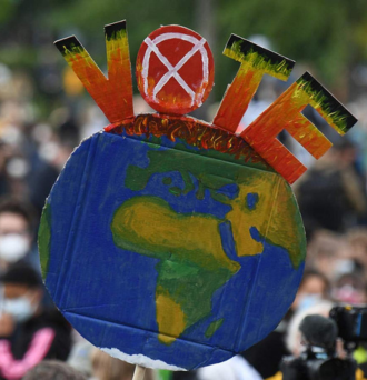 A protester holds up an Earth-shaped sign reading “Vote.”(Tobias Schwarz / AFP via Getty Images)